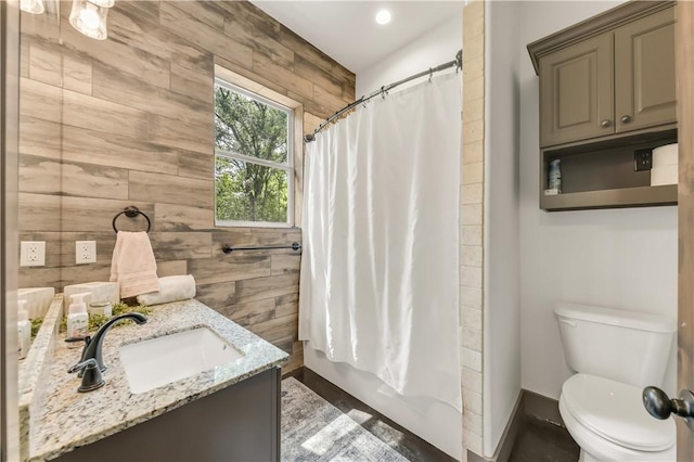 bathroom with vanity, shower / tub combo with curtain, tile walls, toilet, and recessed lighting