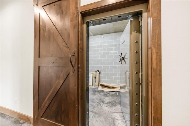 bathroom with concrete flooring and baseboards