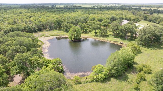 aerial view featuring a wooded view and a water view