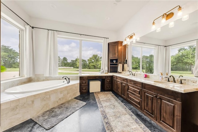 full bathroom with finished concrete floors, a sink, double vanity, and plenty of natural light