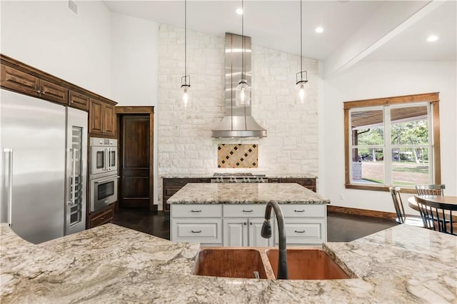 kitchen featuring vaulted ceiling, decorative backsplash, stainless steel appliances, and a sink