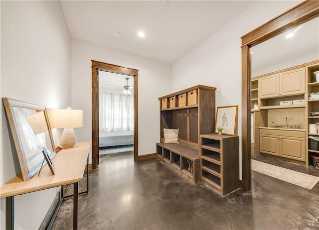 mudroom with ceiling fan, a sink, and finished concrete flooring