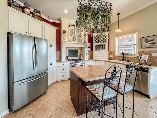 kitchen featuring white cabinets, stainless steel appliances, crown molding, and sink