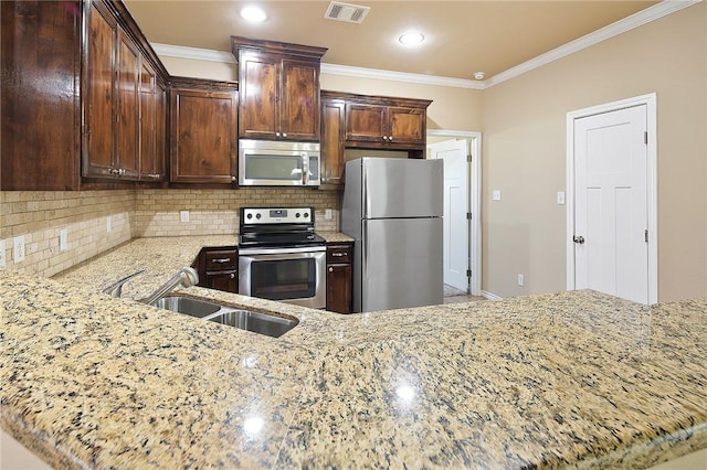 kitchen featuring sink, light stone counters, kitchen peninsula, crown molding, and appliances with stainless steel finishes