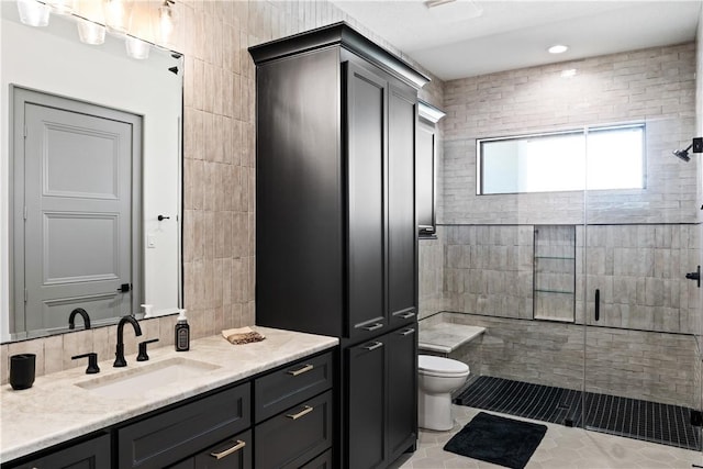 bathroom with toilet, vanity, a shower with shower door, and tile patterned floors