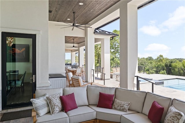 sunroom / solarium with ceiling fan, vaulted ceiling, wood ceiling, and a healthy amount of sunlight