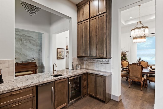 kitchen with dark wood-type flooring, decorative light fixtures, stainless steel fridge, beverage cooler, and sink