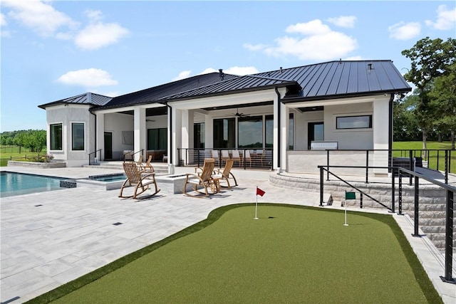 rear view of property with a pool with hot tub, a patio area, and ceiling fan