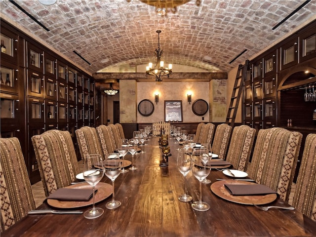 wine room featuring brick ceiling, lofted ceiling, a chandelier, and wood-type flooring