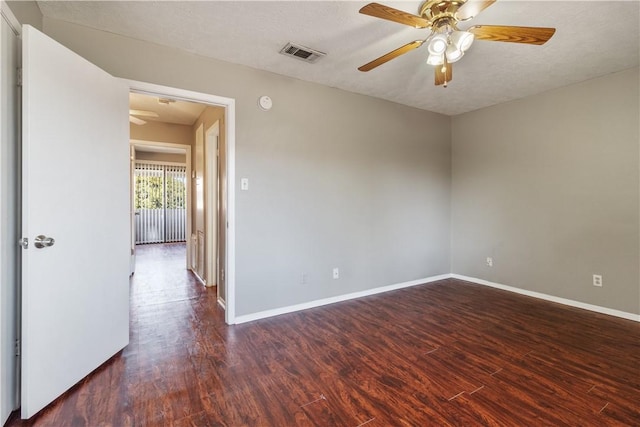 spare room featuring ceiling fan, dark hardwood / wood-style flooring, and a textured ceiling