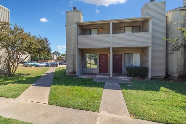 view of front of property with a balcony and a front yard