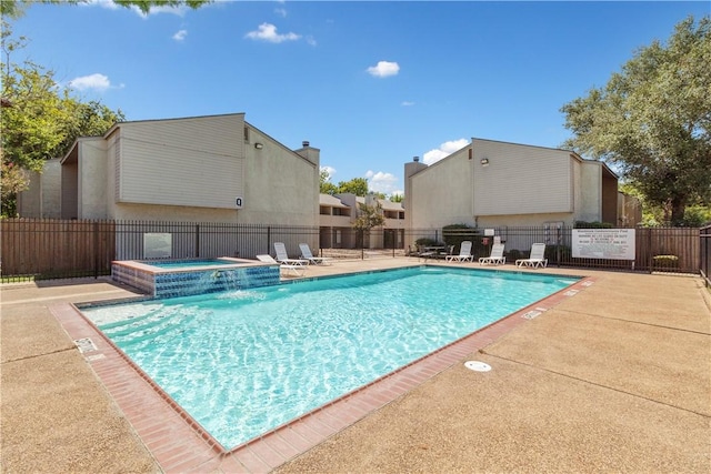 view of swimming pool with pool water feature, a patio area, and a hot tub