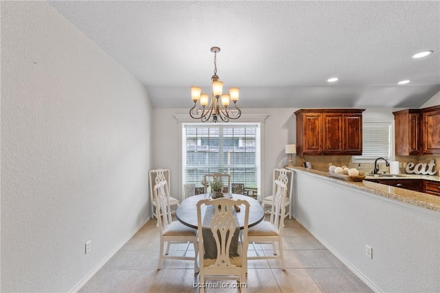 tiled dining area with a textured ceiling, lofted ceiling, sink, and an inviting chandelier