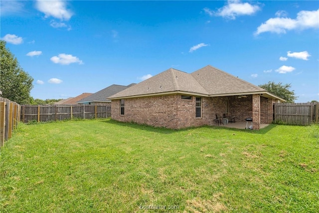 back of house featuring a lawn and a patio area