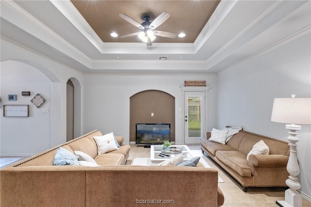 living room featuring a tray ceiling, crown molding, and ceiling fan