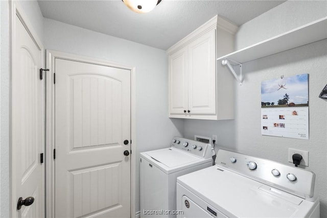 washroom with cabinets, a textured ceiling, and independent washer and dryer