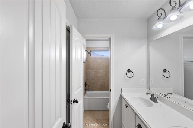 full bathroom featuring tile patterned floors, vanity, a textured ceiling, toilet, and tiled shower / bath