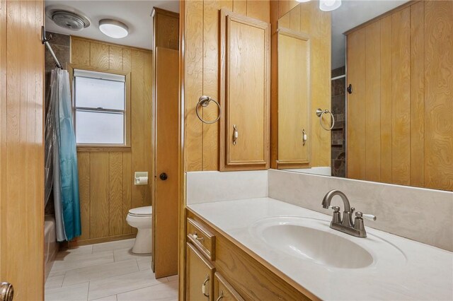 full bathroom with toilet, vanity, shower / tub combo with curtain, tile patterned flooring, and wood walls