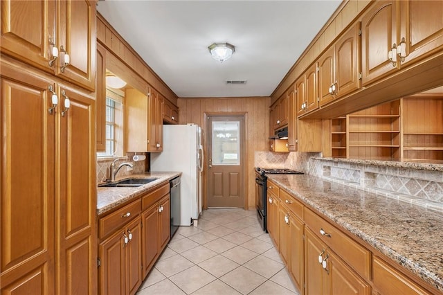 kitchen featuring black range with gas stovetop, a sink, stainless steel dishwasher, backsplash, and light tile patterned flooring
