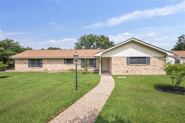 ranch-style house featuring brick siding and a front yard