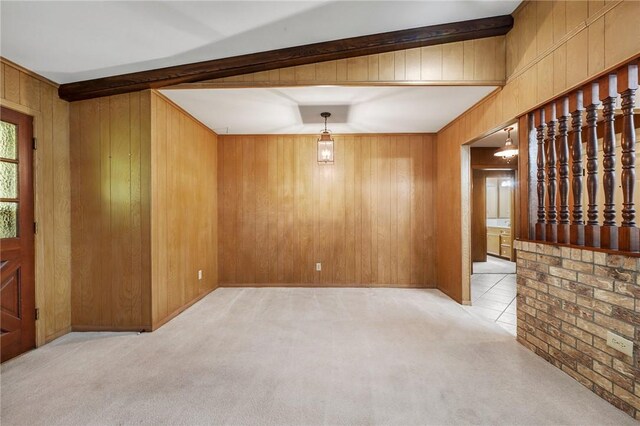 carpeted empty room featuring wooden walls