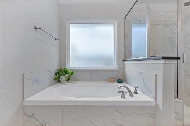 bathroom featuring a garden tub and walk in shower