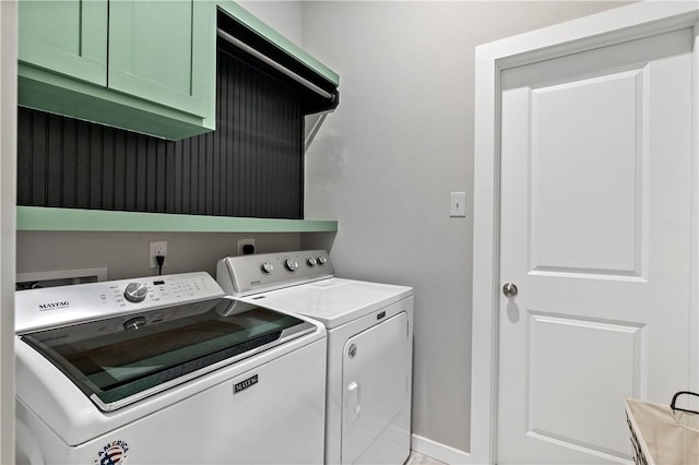 clothes washing area featuring cabinet space, washer and clothes dryer, and baseboards