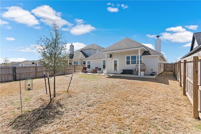 rear view of house with a patio area, a fenced backyard, a chimney, and a lawn