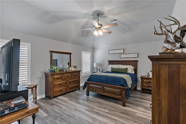 bedroom with visible vents, a ceiling fan, vaulted ceiling, light wood-type flooring, and baseboards