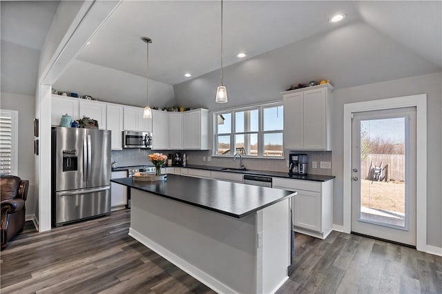 kitchen featuring lofted ceiling, dark wood-style flooring, white cabinetry, appliances with stainless steel finishes, and dark countertops