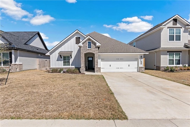 view of front of property with concrete driveway, a front lawn, board and batten siding, and an attached garage