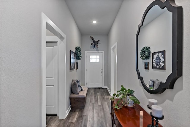 doorway with wood finished floors and baseboards