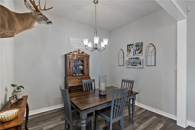 dining room with dark wood-style flooring, baseboards, and an inviting chandelier