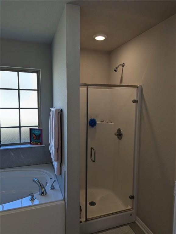 bathroom featuring separate shower and tub