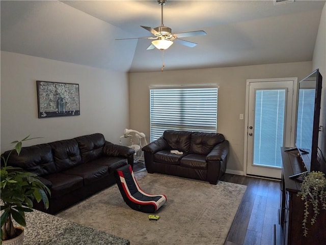 living room featuring dark wood-type flooring, ceiling fan, and vaulted ceiling