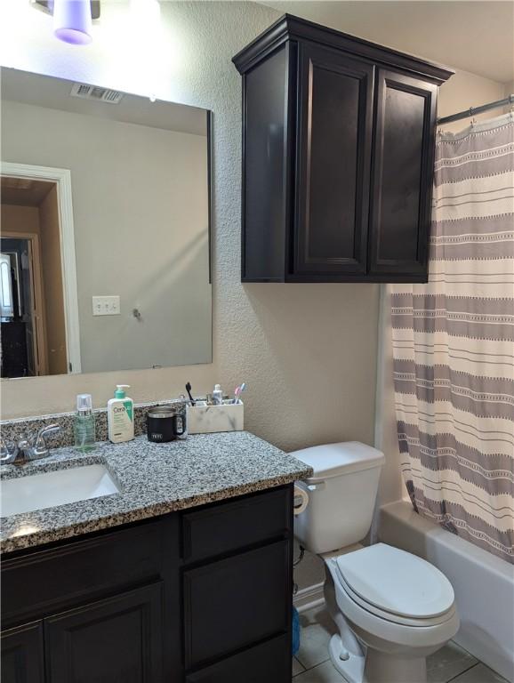 full bathroom featuring vanity, shower / bath combo, tile patterned floors, and toilet