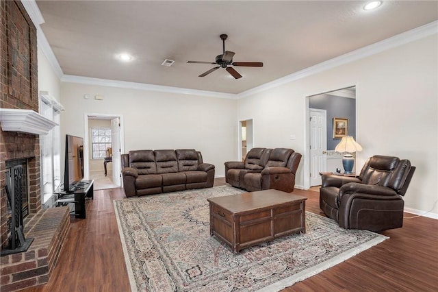 living room with a brick fireplace, ceiling fan, ornamental molding, and dark hardwood / wood-style floors