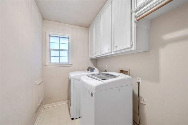 clothes washing area featuring cabinets and independent washer and dryer