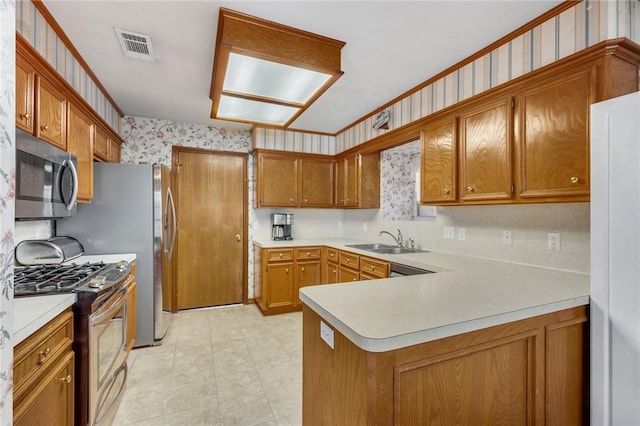 kitchen featuring kitchen peninsula, appliances with stainless steel finishes, ornamental molding, and sink