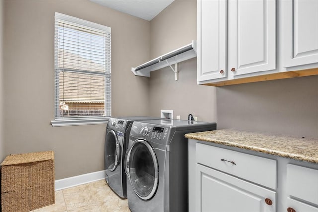 washroom featuring washer and clothes dryer, light tile patterned floors, and cabinets