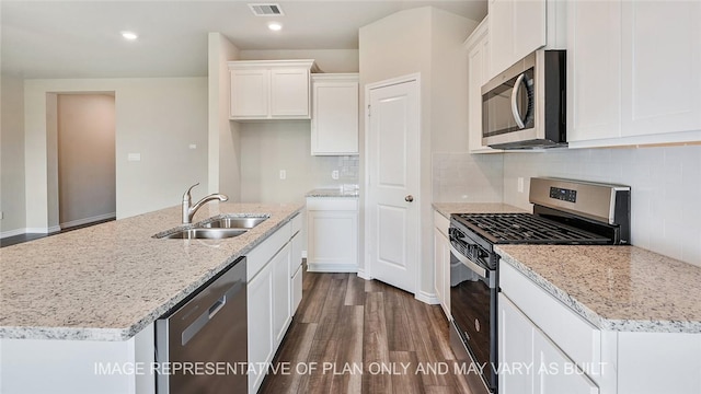 kitchen featuring white cabinets, a kitchen island with sink, stainless steel appliances, sink, and backsplash