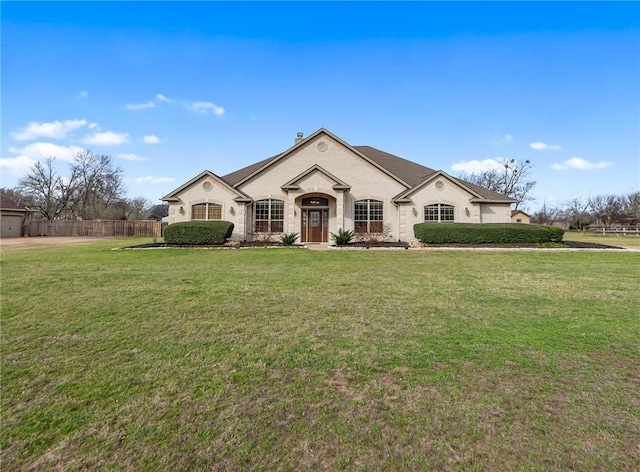 french country style house with a front yard and fence