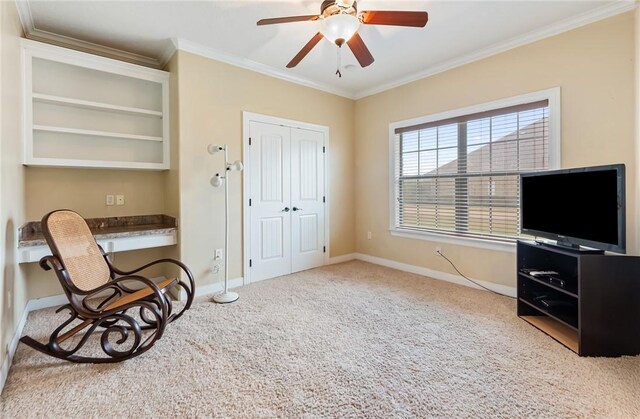 sitting room featuring crown molding, baseboards, carpet floors, and built in study area