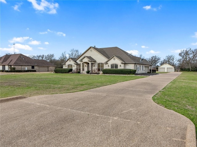 french provincial home with a front yard, an outdoor structure, and a detached garage