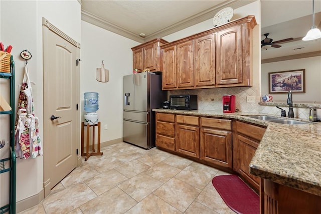 kitchen with a sink, tasteful backsplash, stainless steel refrigerator with ice dispenser, and crown molding