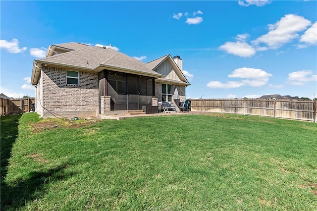 back of house featuring a lawn, a patio area, and a sunroom