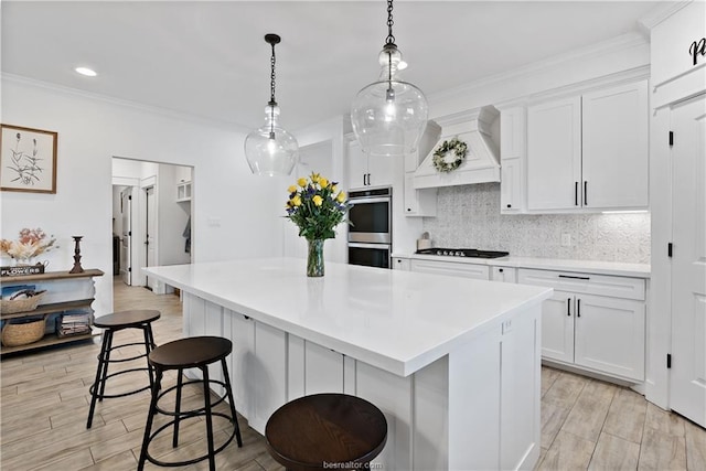 kitchen featuring backsplash, a center island, and white cabinets