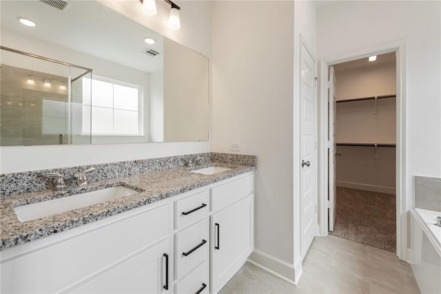 bathroom with tile patterned floors, vanity, and shower with separate bathtub