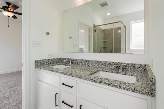 bathroom featuring ceiling fan, a shower with shower door, and vanity