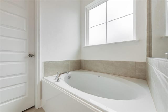 bathroom featuring a healthy amount of sunlight and a tub